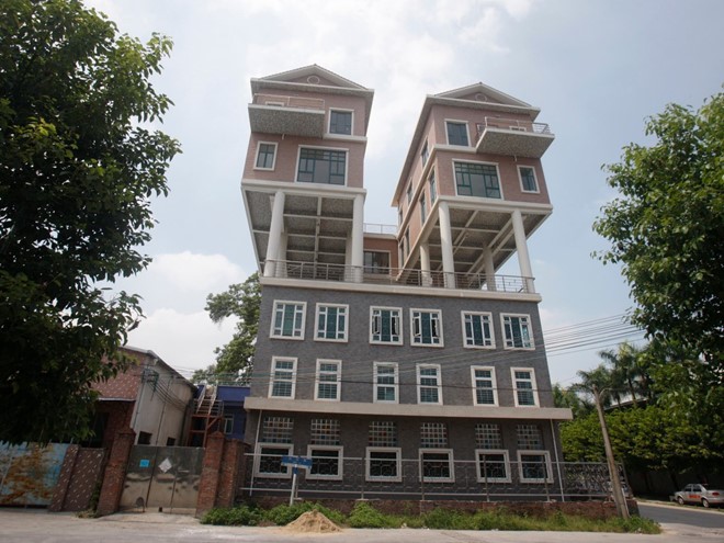 Tại tỉnh Quảng Đông, Trung Quốc, người ta xây 2 ngôi nhà trên đỉnh một ngôi nhà khác vào năm 2011. Theo giới truyền thông nước này, công trình sau khi hoàn thiện vượt quá kích thước theo kế hoạch khiến chúng bất hợp pháp về mặt kỹ thuật. Ảnh: 