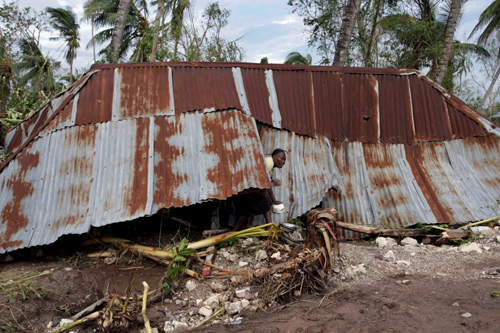 Người phụ nữ bước ra khỏi ngôi nhà bị phá hủy bởi cơn bão Matthew ở Cavaillon, Haiti hôm 16/10