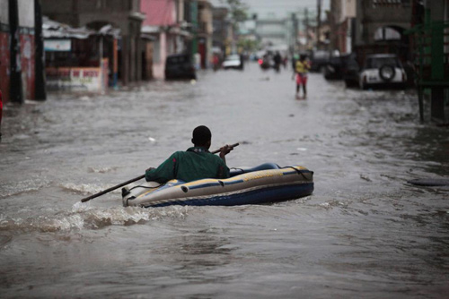 Người đàn ông chèo thuyền  trên con phố ngập nước ở Les Cayes, Haiti trong đợt siêu bão Matthew.
