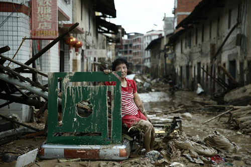 Người phụ nữ ngồi bất lực giữa đống đổ nát sau khi siêu bão Nepartak càn quét qua huyện Minqing, tỉnh Phúc Kiến, Trung Quốc hôm 10/7.