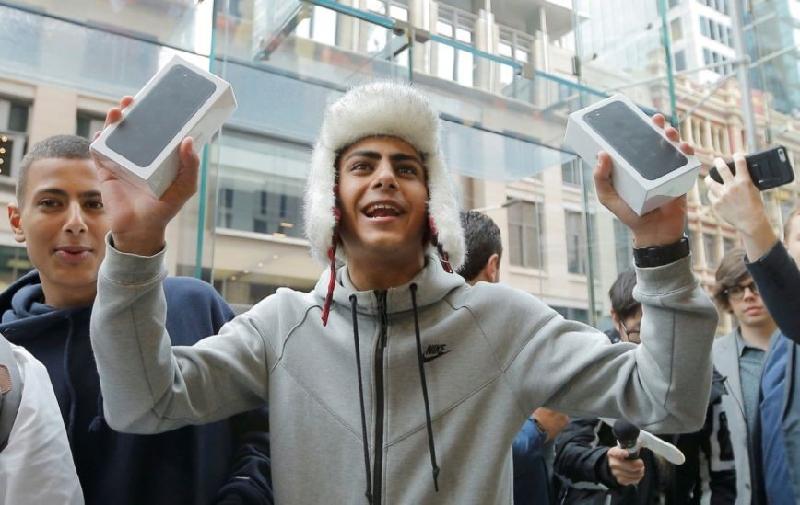 Sinh viên người Australia Bishoy Bahman, 17 tuổi, vui mừng khi là một trong những khách hàng đầu tiên bước ra khỏi cửa hàng Apple, đang cầm trên tay chiếc iPhone 7 tại Sydney ngày 16/9/2016. 