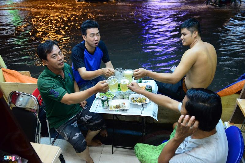 Nhóm bạn của anh Trương Công Lý nhậu giữa dòng nước ngập trên đường Phan Đình Phùng, quận Phú Nhuận.
