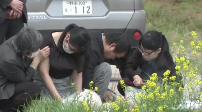 Bố mẹ của bé Linh thắp nhang tại nơi thi thể con gái được phát hiện. Ảnh chụp màn hình.
