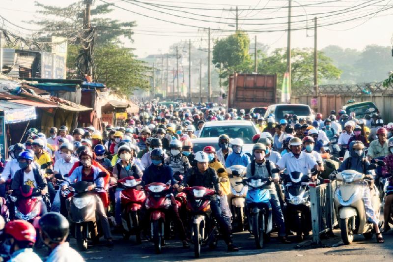 Ôtô và xe máy chen lấn nhau trên con đường tắc nghẽn tại Việt Nam, nhiều người đeo khẩu trang để tránh khí thải.