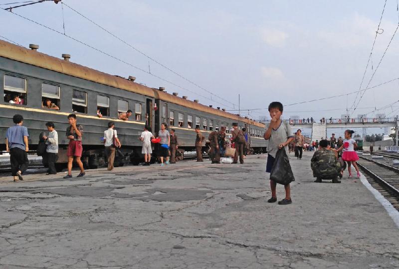Mỗi khi tàu đỗ tại ga, Chu lại thấy những cảnh gợi nhắc đến điều kiện sống nghèo khổ của quốc gia này. Trong ảnh, một cậu bé đang đứng xin tiền ở ga Hamhung.