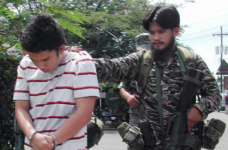 Đặc nhiệm Philippines di lý một thành viên của tổ chức Abu Sayyaf trong chiến dịch trấn áp khủng bố vào năm 2003. Ảnh: 