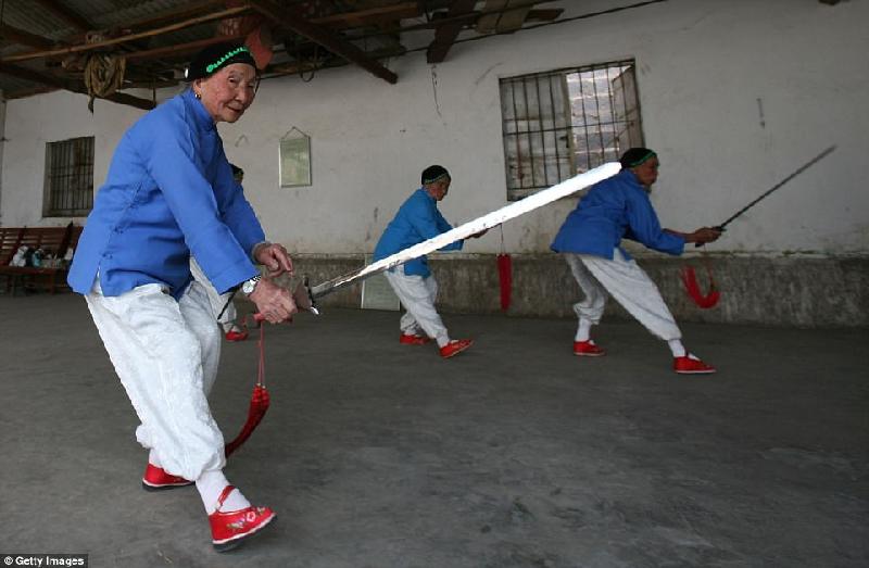 Hiện nay, những người già có đôi chân nhỏ ở làng Liuyi thành lập một đội múa, cùng tập luyện những điệu múa với kiếm trong đôi giày nhỏ như em bé. Ảnh: Getty Images.