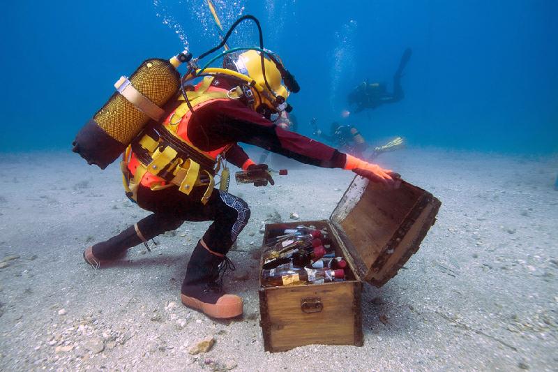 Chôn giấu: Một thợ lặn ở vùng Saint-Mandrier của Pháp mở chiếc hòm chứa những chai rượu Bondol được chôn cất dưới biển Địa Trung Hải trong vòng một năm nhằm nghiên cứu quá trình biến đổi của loại rượu này. Ảnh: AFP.