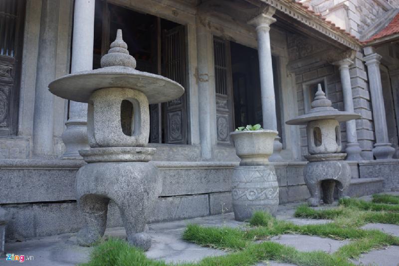 Hai cây đèn đá khổng lồ chế tác theo phong cách cổ xưa, đặt trước bậc thềm.
