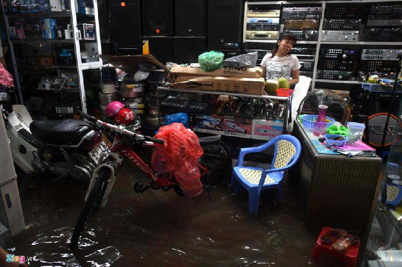 Cơn mưa lớn khiến hoạt động buôn bán đồ điện tử ở phố Hàng Bài bị ngừng trệ. Nhiều người phải di dời tài sản khi mưa lớn kéo dài không ngớt. Ảnh: Tiến Tuấn.