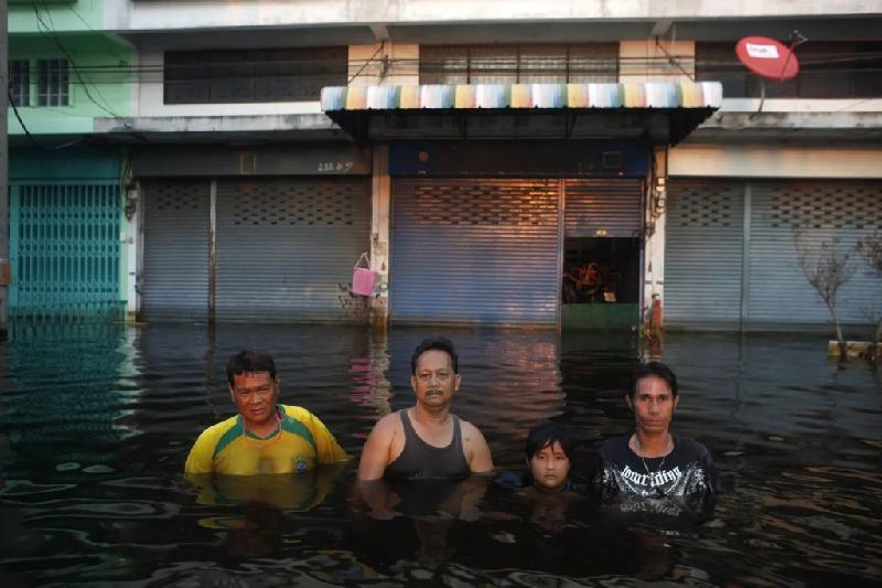 Bangkok, Thái Lan: Người dân địa phương di chuyển trong nước lụt ngập tới ngang ngực ở làng Amornchai, ngoại ô Bangkok.