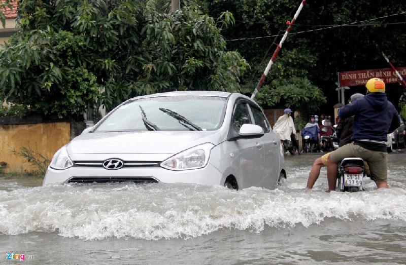 Nước ngập sâu, ôtô chạy nhanh tạo sóng nước khiến nhiều người điều khiển xe máy bị loạng choạng tay lái.