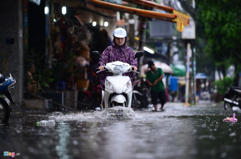 Người đi xe máy phải chạy sát lề đường, tránh vùng nước ngập sâu.