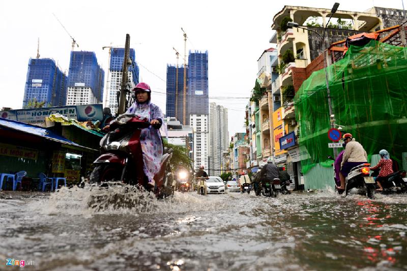 Phương tiện di chuyển khó khăn qua dòng nước ngập trong hẻm 602 Điện Biên Phủ. Con đường này dẫn ra đường Nguyễn Hữu Cảnh, một nơi thường xuyên bị ngập sau mưa.
