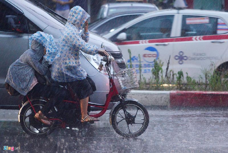 Học sinh trên đường từ trường về nhà chỉ kịp mặc chiếc áo mưa mỏng nên vẫn bị ướt chân.