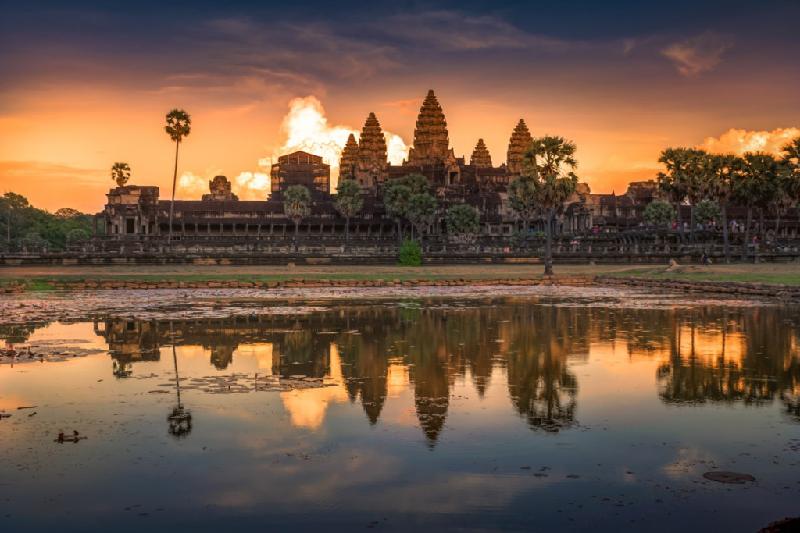 Hình ảnh đền thờ Angkor Wat của Campuchia, trong ánh bình minh trở nên kỳ ảo hơn khi phía xa là đám mây lớn, phản xạ ánh sáng mặt trời trông tựa như một ngọn lửa đang bùng cháy. Ảnh: 