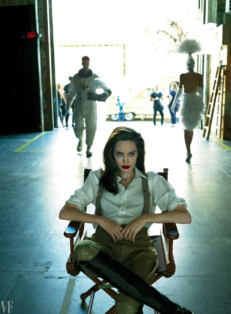 Nữ diễn viên chuyển sang bộ cánh khác với sơ mi và quần thụng kèm dây đeo mạnh mẽ trên chiếc ghế đạo diễn trong phim trường ở Warner Bros.. Vài năm nay, Angelina chuyển sang lĩnh vực chỉ đạo phim.