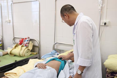 TS Nguyễn Duy Cường đang khám cho một trường hợp bị sốt xuất huyết nặng ở BV Bạch Mai.