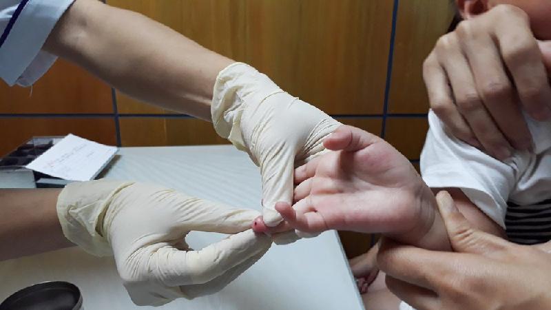 Lấy mẫu máu của một khách hàng để xét nghiệm ADN. 