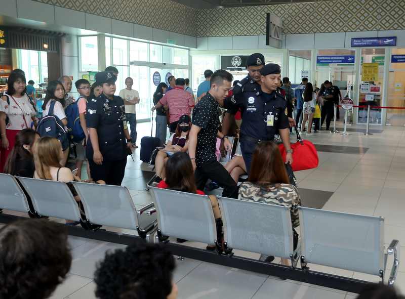 Choon giả vờ bị cảnh sát bắt ngay trước mắt Yee. (Ảnh: The Malaysiaonline)