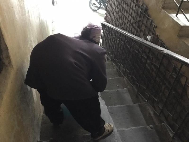 Một cụ bà đang dọn vệ sinh ở cầu thang khu tập thể Thành Công. Ảnh: Thanh Hải