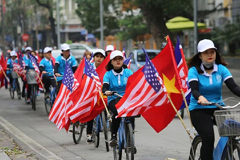 Các bạn trẻ đạp xe quanh các tuyến phố Hà Nội, mang theo quốc kỳ Mỹ, Triều Tiên và Việt Nam, trước thềm Hội nghị Thượng đỉnh Mỹ - Triều. Ảnh: ANTĐ
