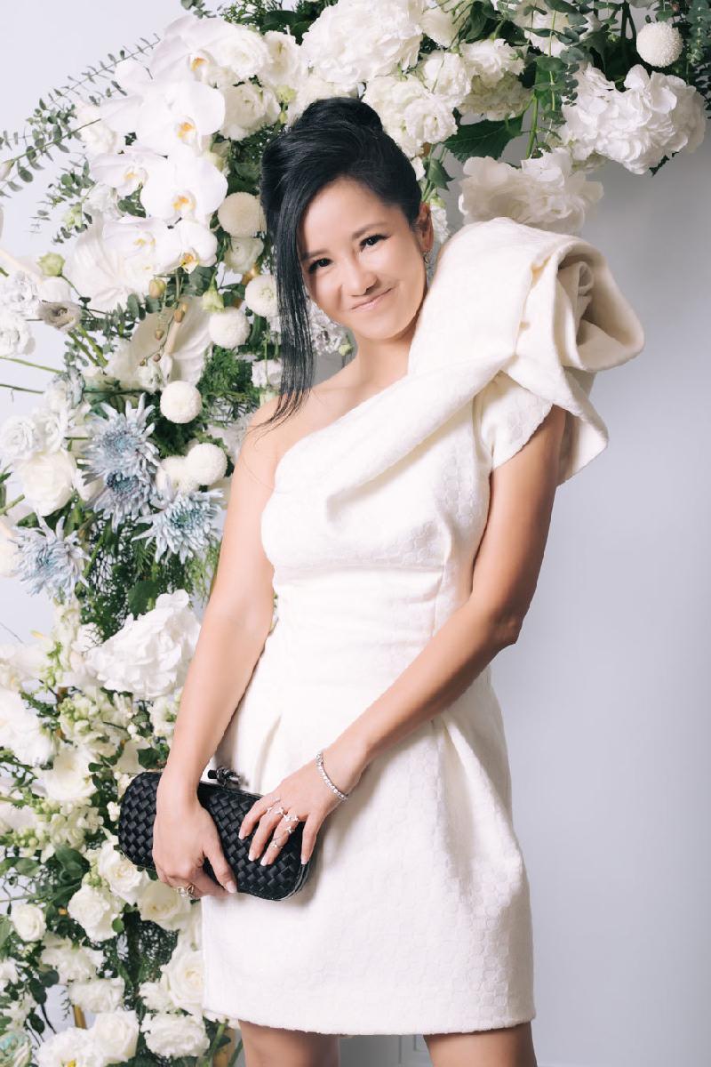 Diva Hồng Nhung chọn dáng váy trên gối với điểm nhấn ở hoạ tiết hoa 3D to bản ở cầu vai. Diva của làng nhạc Việt búi tóc, trang điểm tông trầm tăng thêm vẻ quyến rũ.
